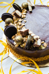 Appetizing chocolate cake with sweets and biscuits. Modern decoration of cake. A great birthday cake!