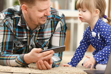 Cute little girl on floor carpet with dad