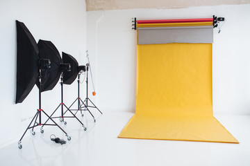 Photographing studio with light set up, modern lightning equipment for making high quality photos. Professional photographer`s work place. Nobody models. Empty studio