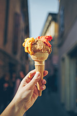 Woman's hand holding cone with italian ice cream.
