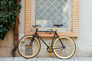 Fototapeta na wymiar Black retro bike parking at wall of building.