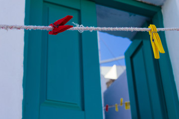 A close up of colorful clothespins front of the entrance a Cycladic house