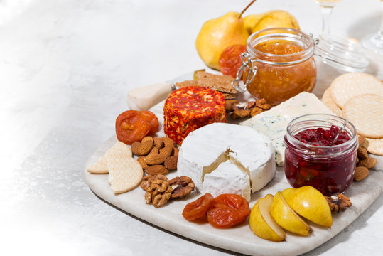 assortment of delicacy cheeses and snacks on board