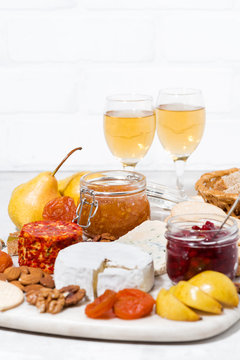 assortment of snacks - cheeses, nuts, fruits and wine, vertical
