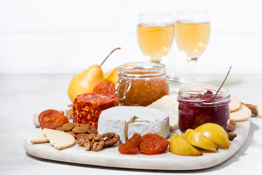 assortment of snacks - cheeses, nuts, fruits and wine