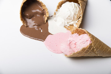 Variety of ice cream scoops in cones with chocolate, vanilla and strawberry
