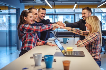 Coworkers in a meeting putting hands all together