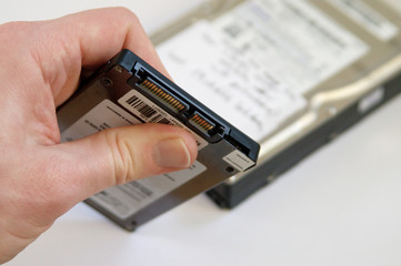 Hand holding SSD Drive, replacing a 3.5 inch HDD