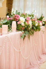 Beautiful setting of wedding party in restaurant. Tables and chairs decorated with flowers and fabrics gently pink in color