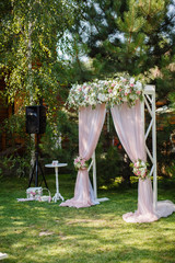 Wedding ceremony in beautiful garden. Elegant decoration of wedding ceremony in pretty pink colors. Outdoors wedding