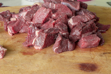 Raw meat is sliced for cooking.