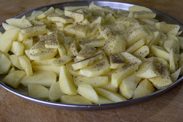 Raw potatoes sliced for cooking French fries in a rustic manner.