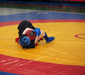 Two boys are fighting on the wrestling mat