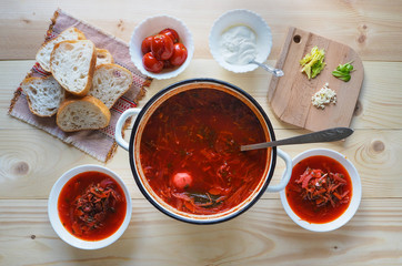 Ukrainian traditional borsch. Russian vegetarian red soup in white bowl on wooden background. Top view.
