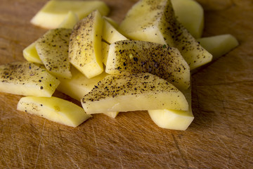 Raw potatoes sliced for cooking French fries in a rustic manner.