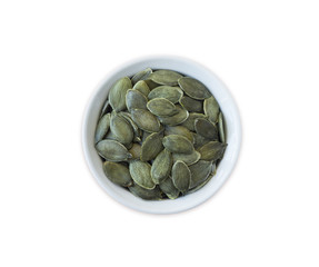 pumpkin seeds isolated on white background. Top view. Pumpkin seeds in a bowl isolated on white background. Pumpkin seeds with copy space for text.