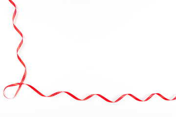 Red and white polka dot ribbon on white background