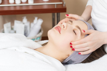 Obraz na płótnie Canvas Facial massage for a beautiful girl in a spa salon