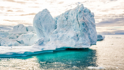 Iceberg aerial footage - giant icebergs in Disko Bay on greenland floating in Ilulissat icefjord from melting glacier Sermeq Kujalleq Glacier, aka Jakobhavns Glacier. Global warming and climate change - obrazy, fototapety, plakaty