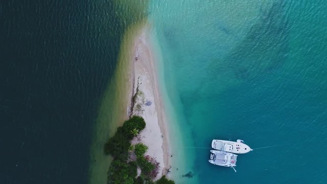 top down drone shot of colourful boats on Caribbean island with aquamarine water