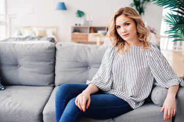Obraz premium young successful business woman relaxing at home on cozy couch. Modern scandinavian interior, start up, home office concept.