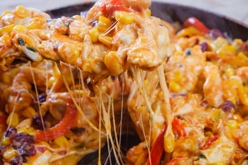 Roasted vegetables and chicken for burritos close-up of cooking burrito.