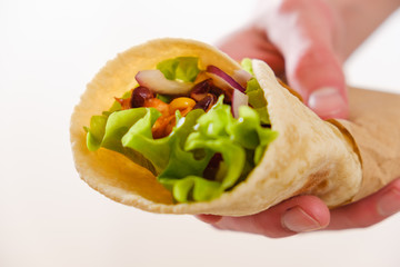 Burrithos with chicken holding in hand, pepper and beans close up