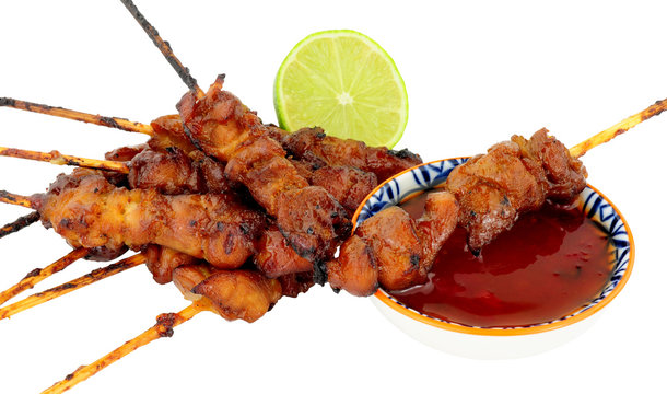 Sticky chicken skewers with chilli sauce dip isolated on a white background