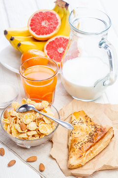 healthy breakfast. bowl of cornflakes, fruit, fresh juice, milk