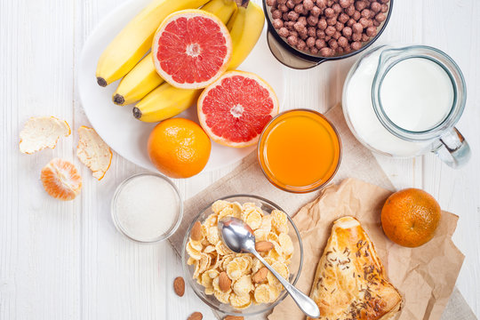 healthy breakfast. bowl of cornflakes, fruit, fresh juice, milk