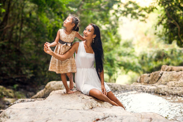 happy mother with her daughter in the tropics near the waterfall. Mothers day.