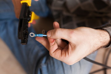 Apartment-repair. Hands, crimper, wire, close up