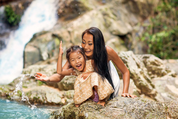 happy mother with her daughter in the tropics near the waterfall. Mothers day.