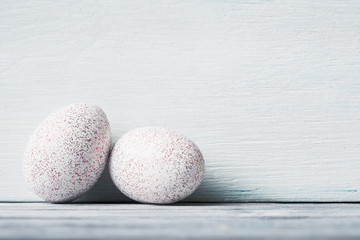 White decorative Easter eggs against light wooden background.