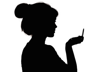 silhouette profile of a woman face looking in a pocket mirror, the concept of the beauty and style