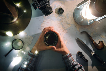 Adventure planning near gas lamp flat lay. Atmospheric old gear on map. Traveler, explorer hands in frame holding cup of tea or coffee. Exploring, hiking poster, postcard.