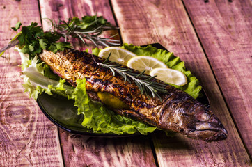still-life with fish on a grill stuffed with lemon and greens