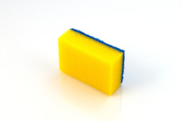 Поролоновая губка желтого цвета с синим слоем полимерного абразива для чистки посуды и бытовых поверхностей.
