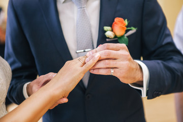 wedding couple pulls each other rings to the finger