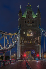 Tower Bridge in the night is opening for cruise and is closing for cars traffic , London, England.