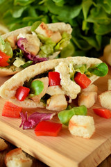 Caesar salad in pita bread on a wooden board
