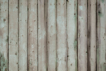 The texture of weathered wooden wall. Close up of gray wooden fence panels