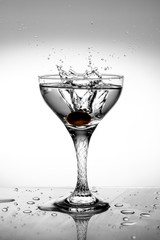Splash in a wineglass with a berry