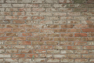 Old brick wall, uneven masonry with concrete spots.