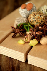 Sweets with different sprinkles, cinnamon, anise stars, mint and pistachio nuts on wooden boards