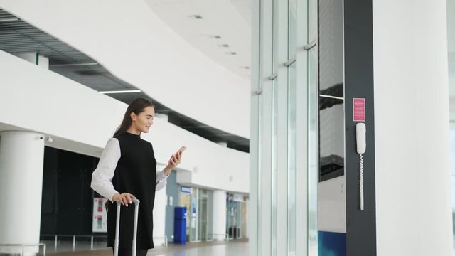 Travel woman using smartphone at airport. Young caucasian traveler checking boarding time with mobile phone app in terminal or train station. Business woman businesswoman Tourist on vacation