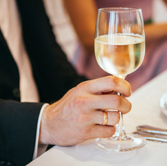 Young wedding holds and climb glasses of champagne