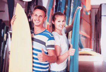 Fototapeta na wymiar Portrait of happy couple standing with new surfboards
