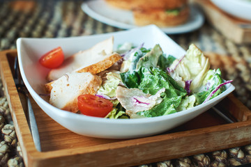 Caesar salad is on the plate in a restaurant.