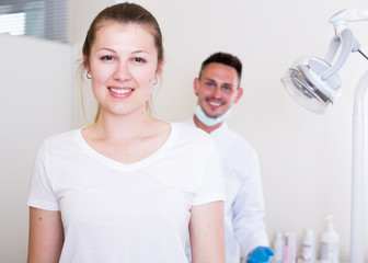 Young woman is sitting satisfied in chair after treatment